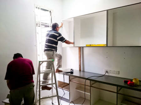 MELAKA, MALAYSIA, 26 JANUARY 2018 : A group of craftsman install a wooden cabinet in the houseのeditorial素材