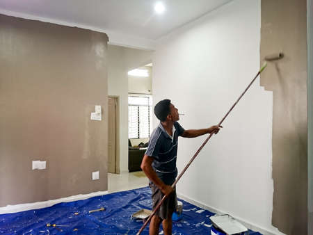 MELAKA MALAYSIA , 24 JANUARY 2018 : General worker of construction paint the wall of the house using roller brushのeditorial素材