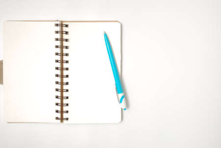 White office desk table with open note book and pen. Top view with copy space, flat lay.の写真素材