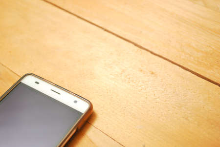 Smartphone on wooden background. Flat lay and from top viewの写真素材