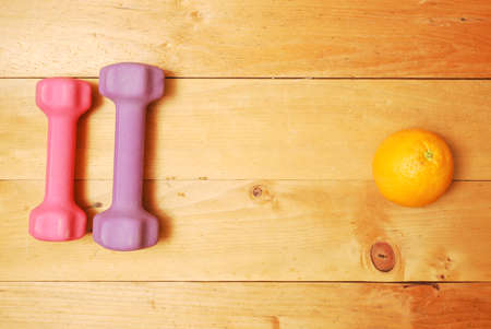 Flat lay of dumbbell, watch strap, heart rate belts, sport shoe, orange from top view. Sport equipments and fitness items concept.の写真素材