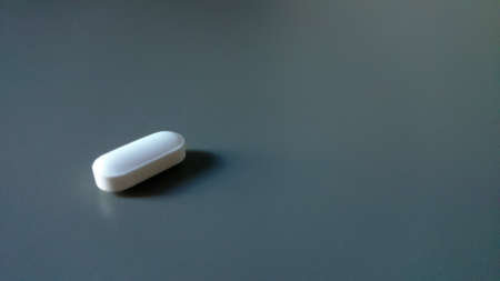 Pills and capsule on grey background. Selective focus and copy space. Creative arrangementの写真素材