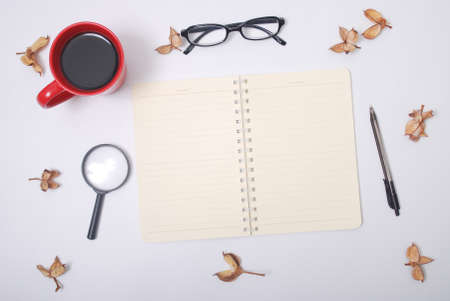 Minimalist notebook on office table desk. Workspace with notebook, spectacle, pen, magnifying glass,...