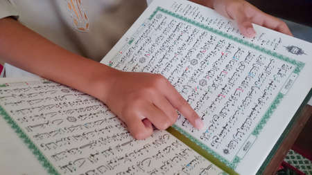 The kid of muslim reading a holy Quran during Ramadan month