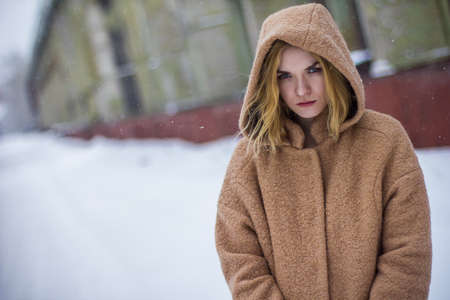 the girl in the coat on the street in winterの写真素材