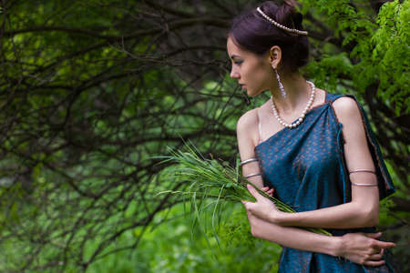girl in dress standing in the forest