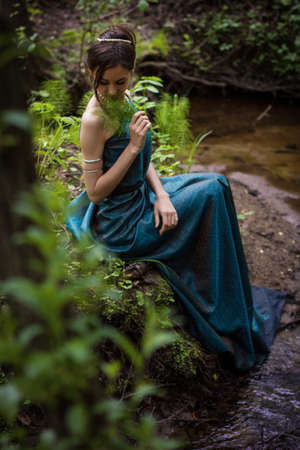 the girl in the dress in the forest near the streamの写真素材