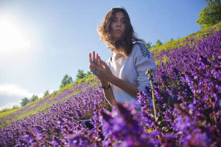 girl sitting on a flower meadowの写真素材