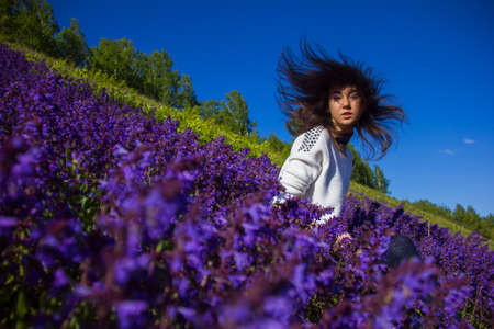 girl sitting on a flower meadowの写真素材