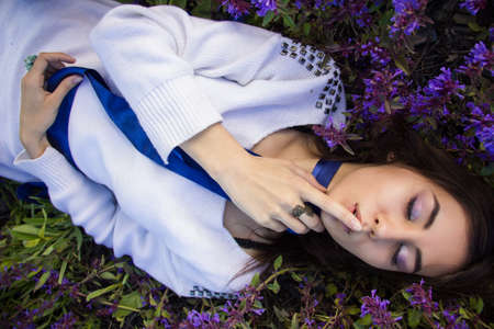 portrait of a girl lying on a flower meadow