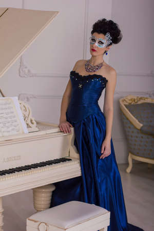 woman in dress Baroque standing at the pianoの写真素材