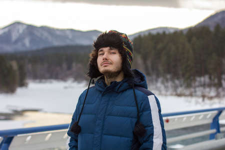 portrait of a man with beard and hat on a background of mountainsの写真素材