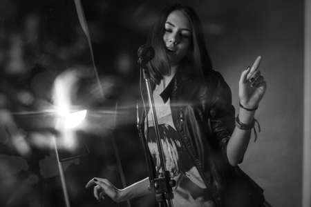 girl singing into a microphone in a studioの写真素材