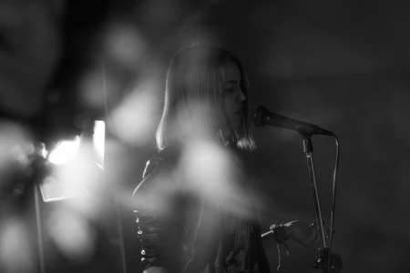 girl singing into a microphone in a studioの写真素材