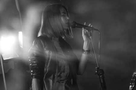 girl singing into a microphone in a studioの写真素材