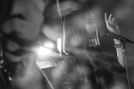 girl singing into a microphone in a studioの写真素材