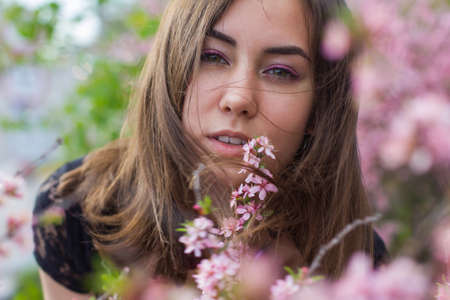 portrait of young beautiful girl in flowersの写真素材