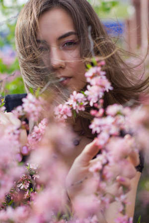 portrait of young beautiful girl in flowersの写真素材