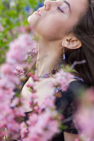 portrait of young beautiful girl in flowersの写真素材