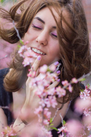 portrait of young beautiful girl in flowersの写真素材
