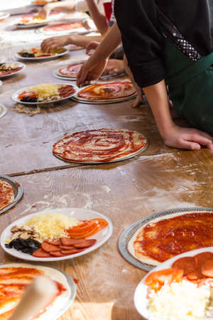 children prepare the pizza in the kitchenの写真素材