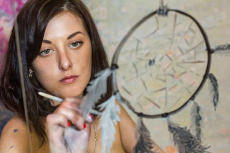 beautiful girl artist paints on glass figureの写真素材