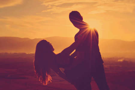 Lovely young couple having fun in each other s arm in the sunset の写真素材