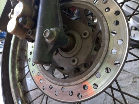 Close-up of the rear brake disc of a motorcycle with a blurred background