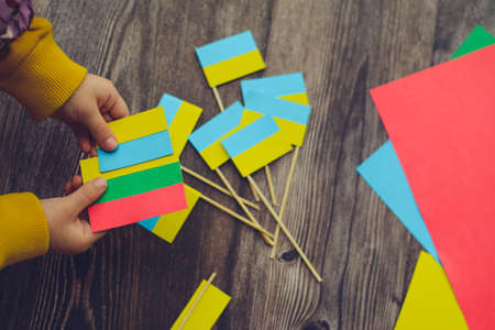 Kids are making small paper flags of Ukraine and Lithuania, Workspace in the kindergartenの写真素材