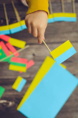 Kids are making small paper flags of Ukraine and Lithuania, Workspace in the kindergarten