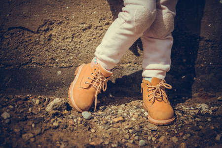Brown girl boots, walking on the road in villageの写真素材