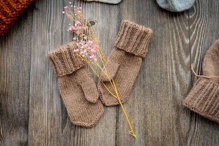 New handmade project, woolen mittens and hat, on dark wooden backgroundの写真素材