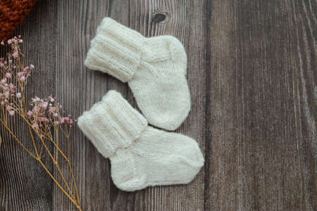 Small woolen baby socks, on dark wooden backgroundの写真素材