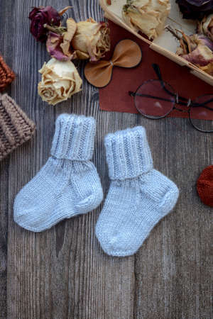 Small woolen baby socks, on dark wooden backgroundの写真素材