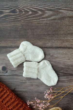 Small woolen baby socks, on dark wooden backgroundの写真素材