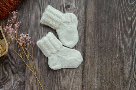 Small woolen baby socks, on dark wooden backgroundの写真素材