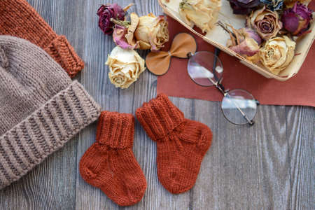 Small woolen baby socks, on dark wooden backgroundの写真素材