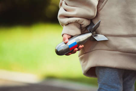 Child is playing with small missile figurine with Russia's flag on itの写真素材
