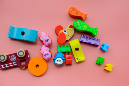 Child is playing with colorful wooden and plastic toys, on pink backgroundの写真素材