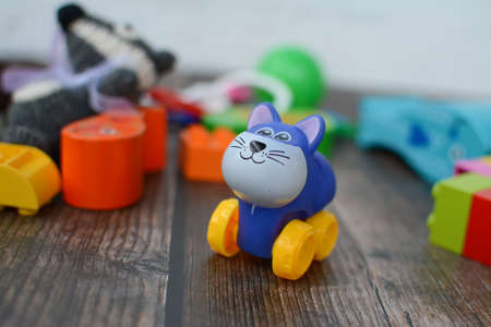 Small plastic and wooden toys in the room on the dark wooden floorの写真素材