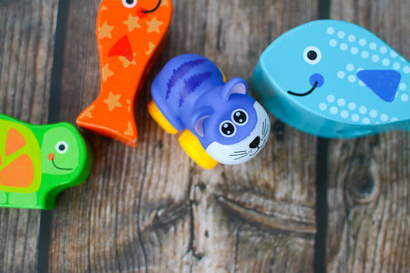 Small plastic and wooden toys in the room on the dark wooden floorの写真素材