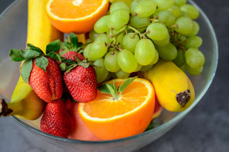 Various fruits and berries for healthy breakfast, on dark background in the kitchenの写真素材