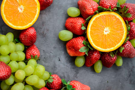 Various fruits and berries for healthy breakfast, on dark background in the kitchenの写真素材