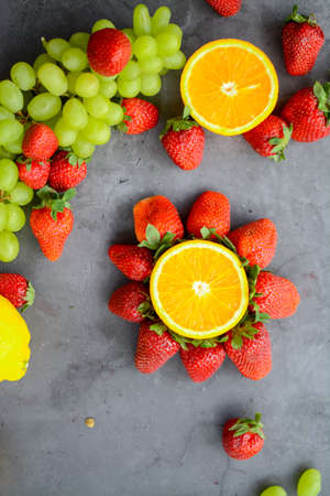 Various fruits and berries for healthy breakfast, on dark background in the kitchenの写真素材