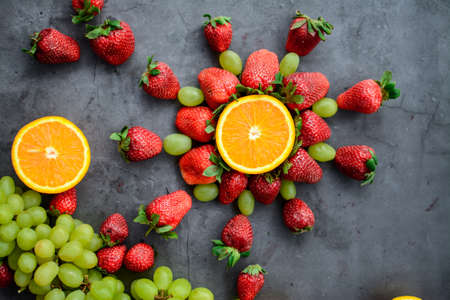Various fruits and berries for healthy breakfast, on dark background in the kitchenの写真素材