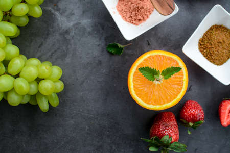 Various fruits and berries for healthy breakfast, on dark background in the kitchenの写真素材