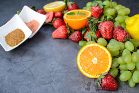 Various fruits and berries for healthy breakfast, on dark background in the kitchenの写真素材
