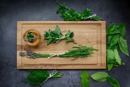 Various herbs picked from the garden, getting ready for drying, on wooden backgroundの写真素材