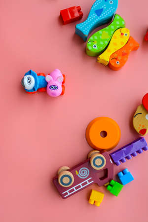 Child is playing with colorful wooden and plastic toys, on pink backgroundの写真素材