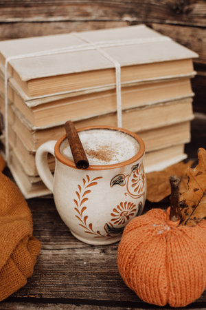 Hot spicy coffee and pile of old books on wooden backgroundの写真素材